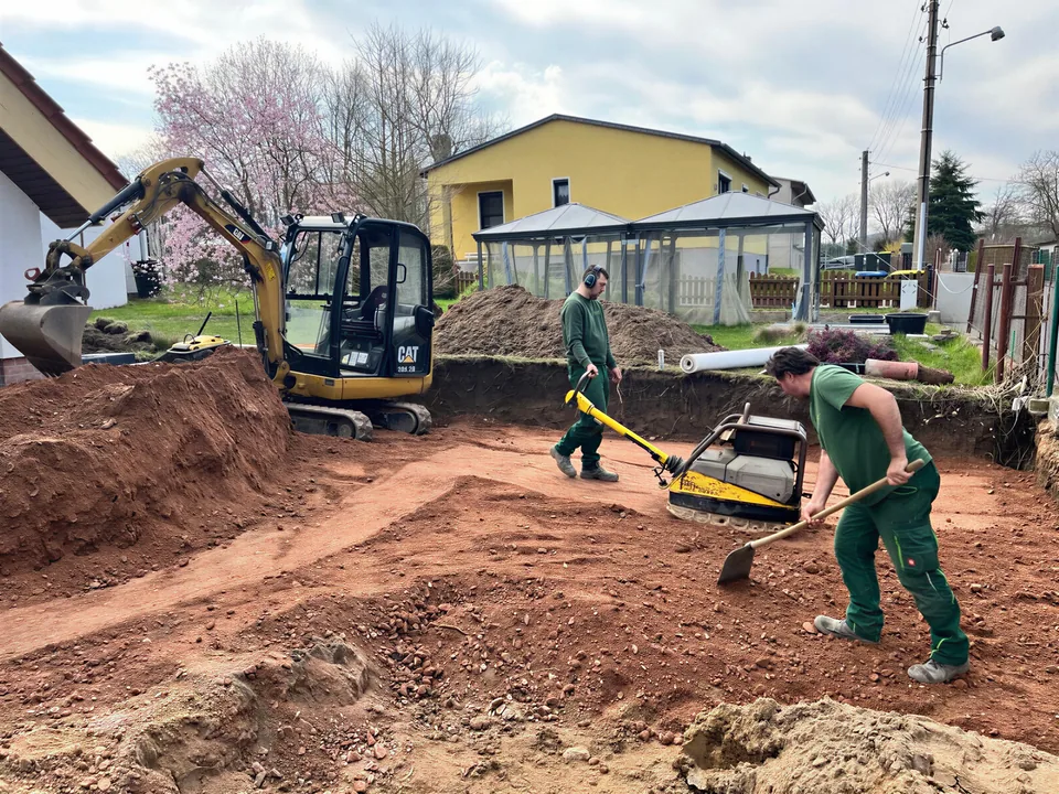 Erdarbeiten mit Minibagger und Rüttelplatte auf einer Baustelle in Sachsen